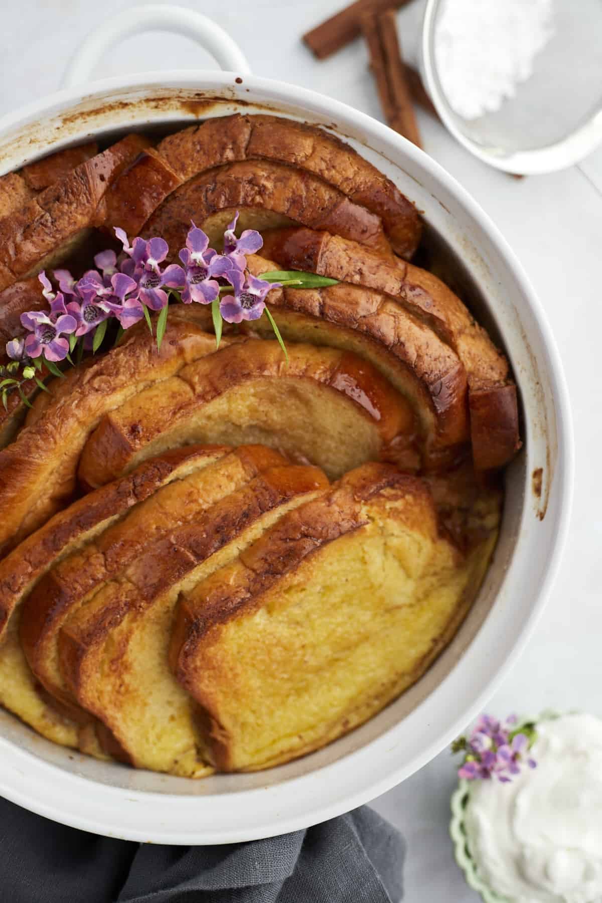 a white baking dish with baked cinnamon french toast