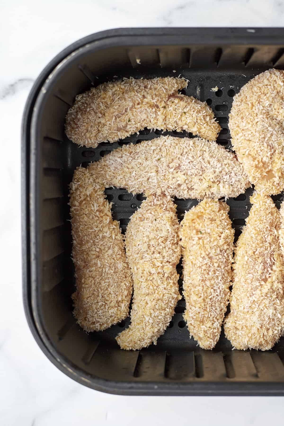 raw coconut chicken tenders in an air fryer