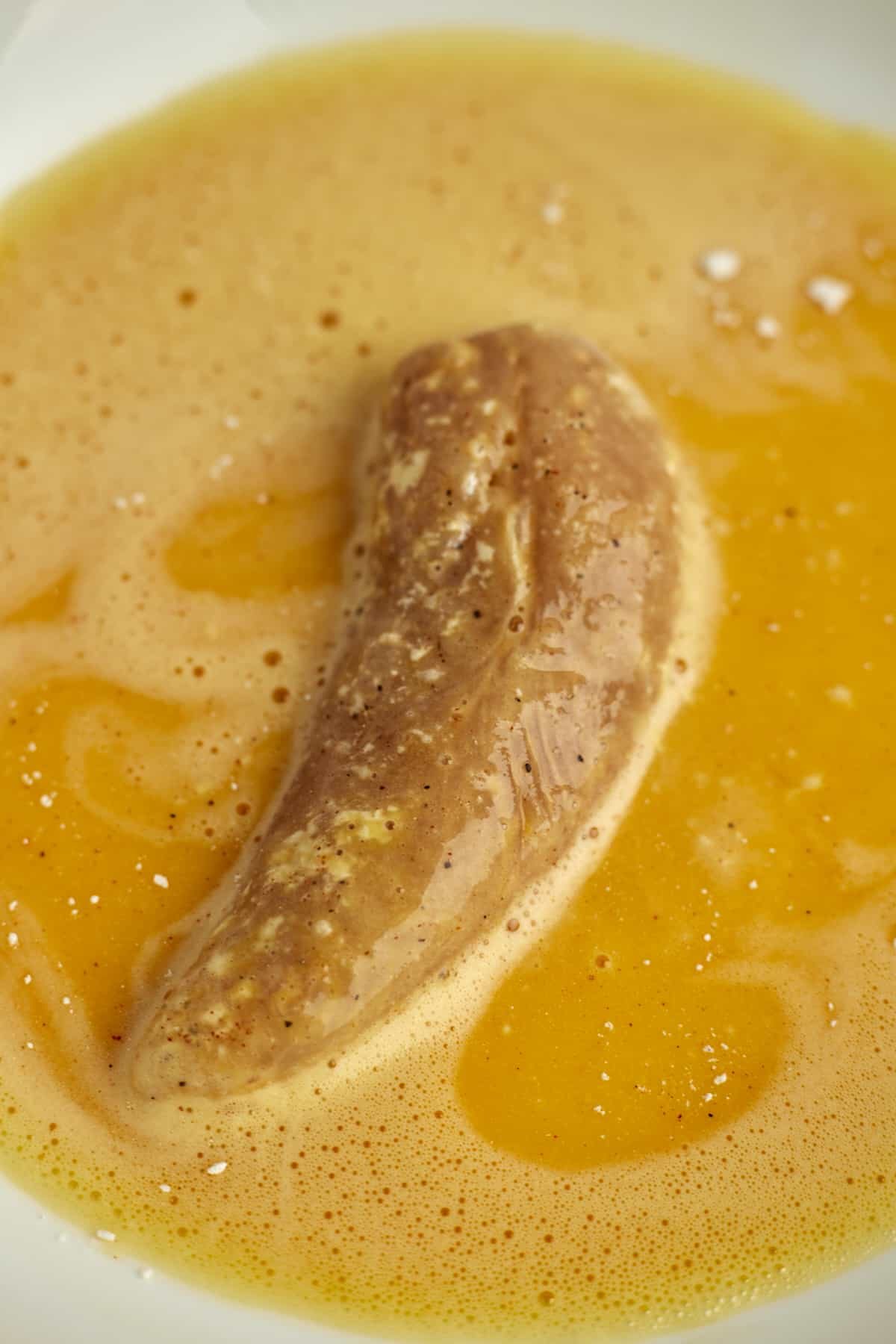 a chicken tender dipped in an egg wash