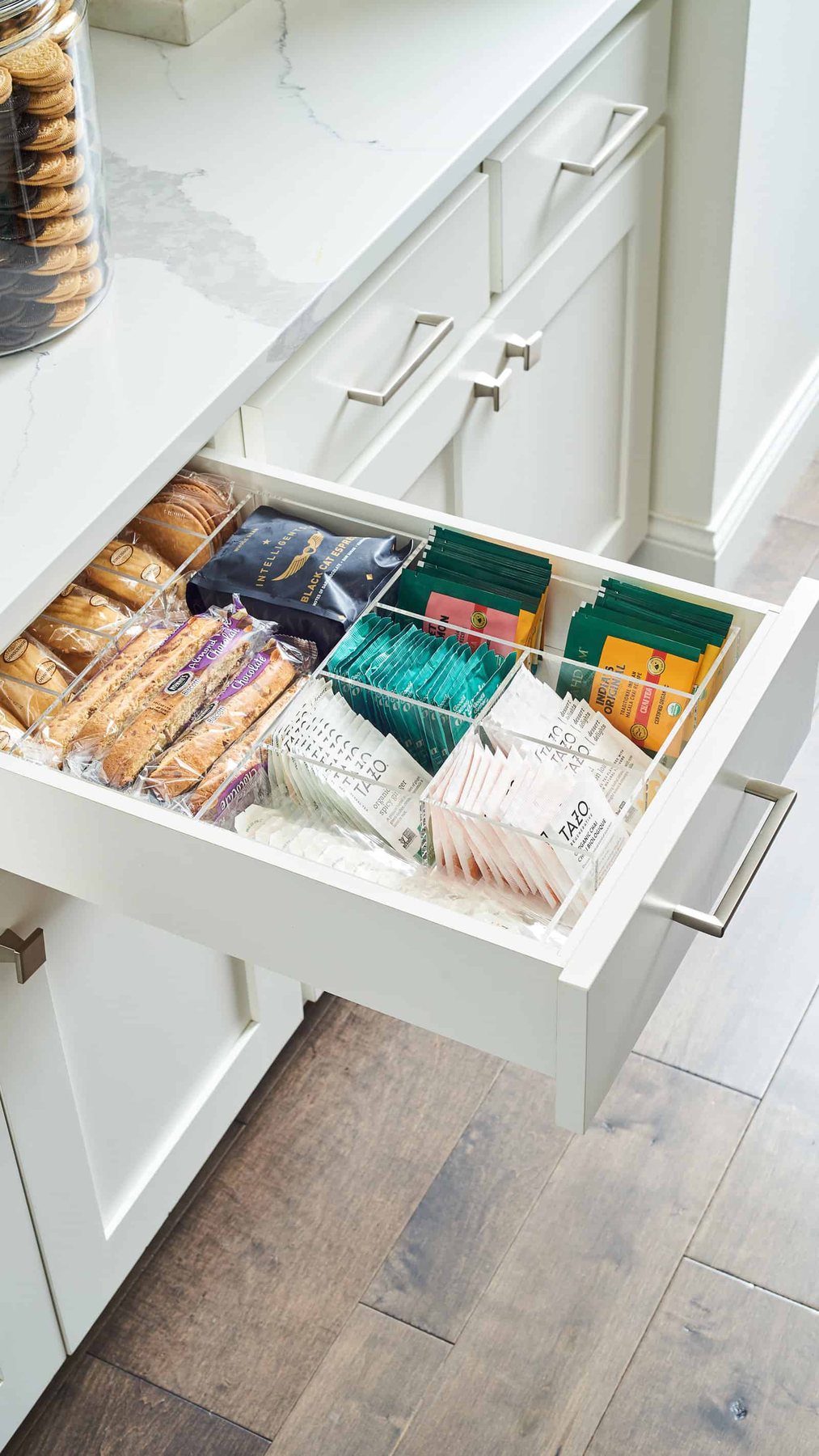 Open drawer with coffee, tea, and snacks.