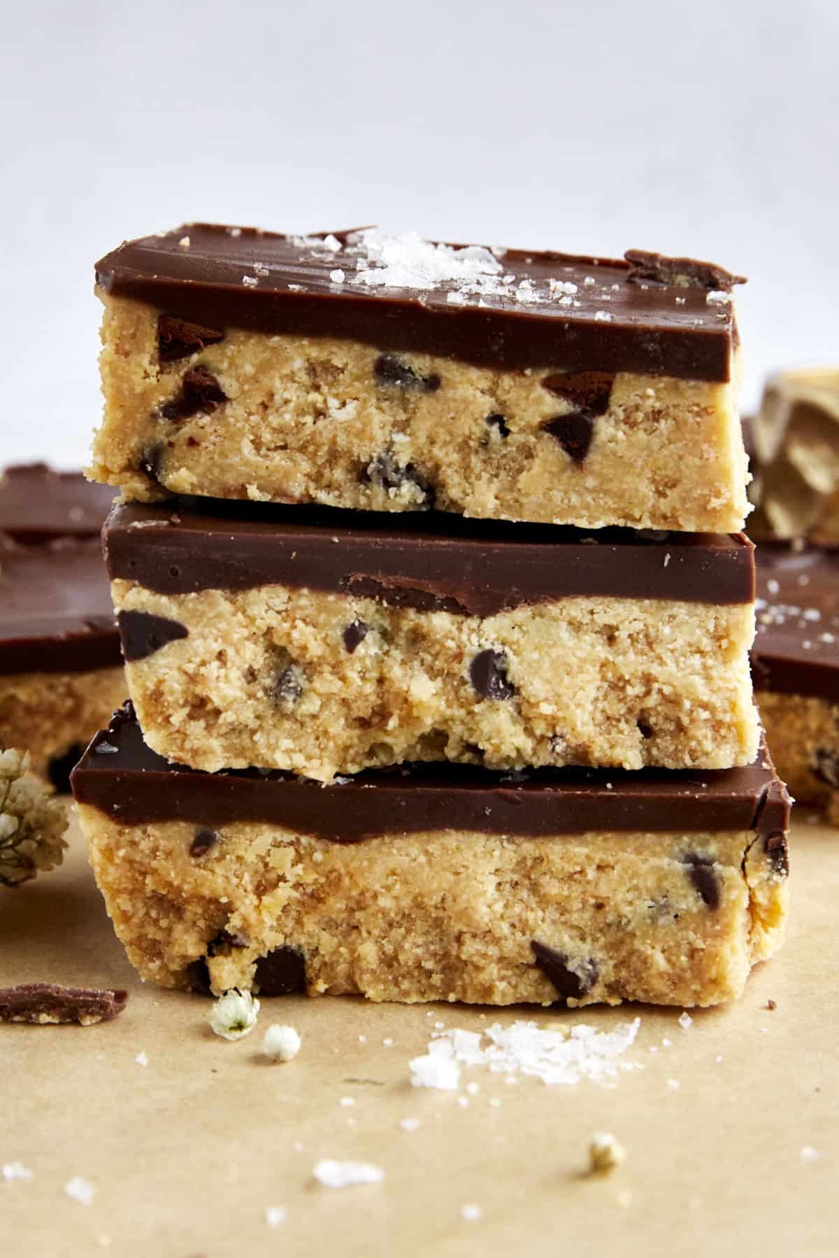 Three no-bake chocolate chip cookie dough bars on top of each other.