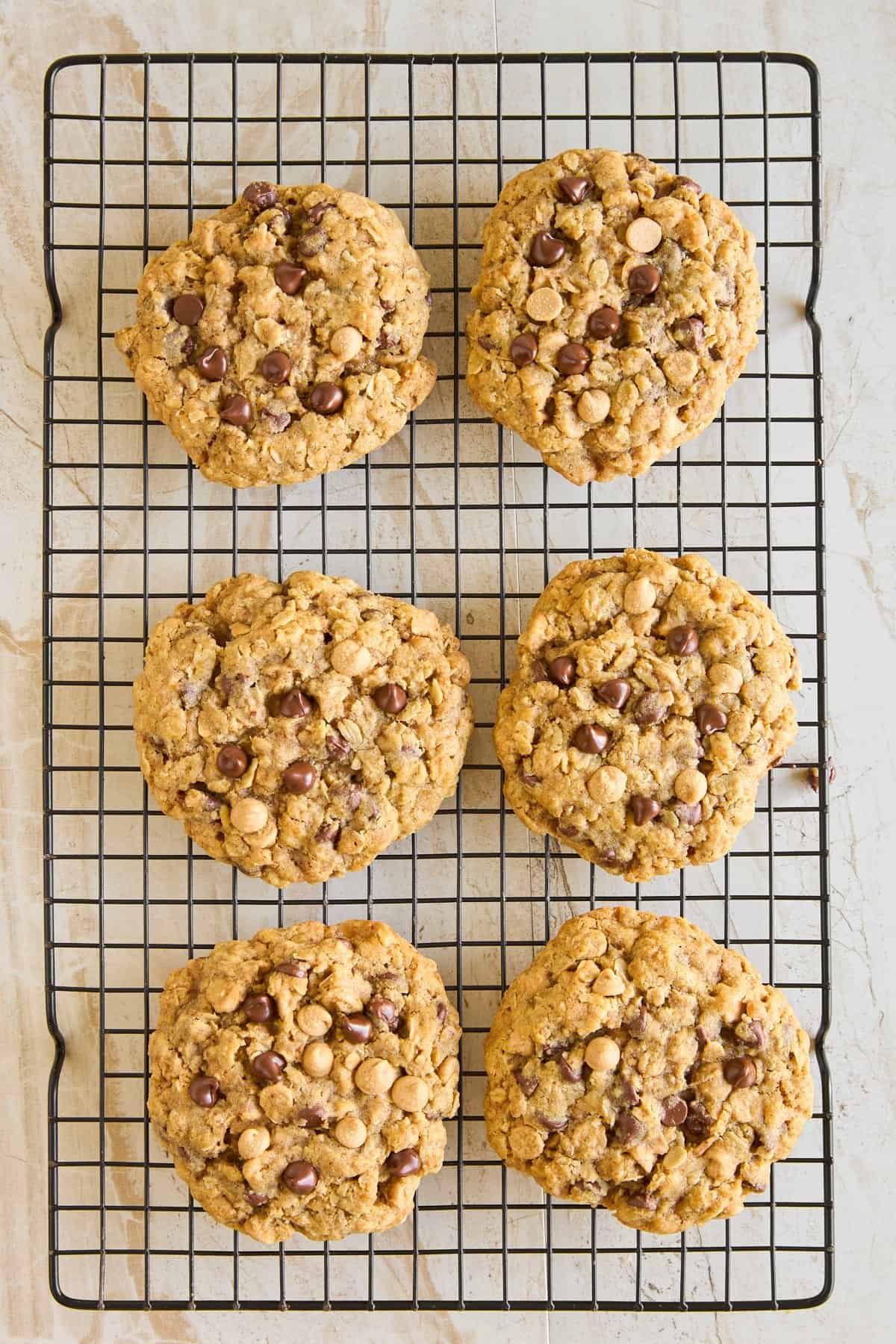 Six baked copycat Crumbl mom's cookies on a wire rack.