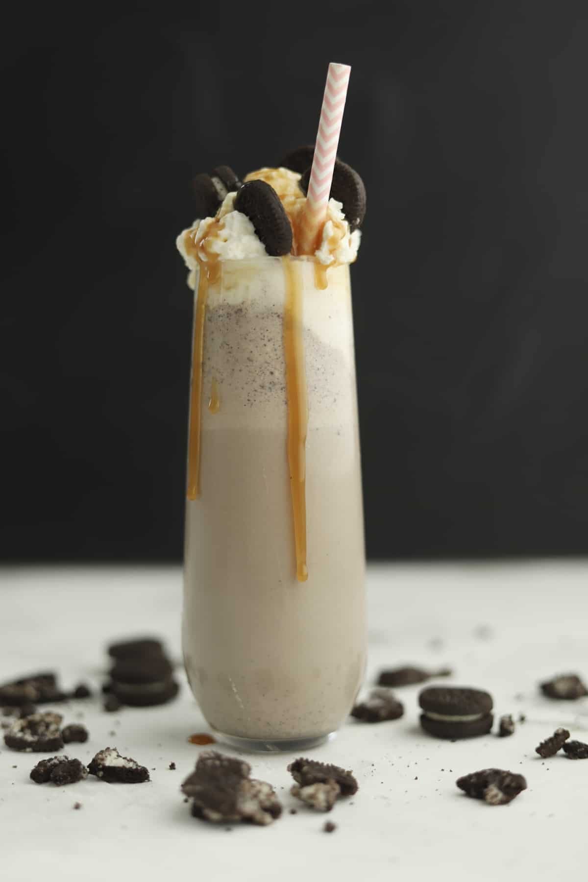 side view of oreo frappuccino with caramel dripping down the side and straw