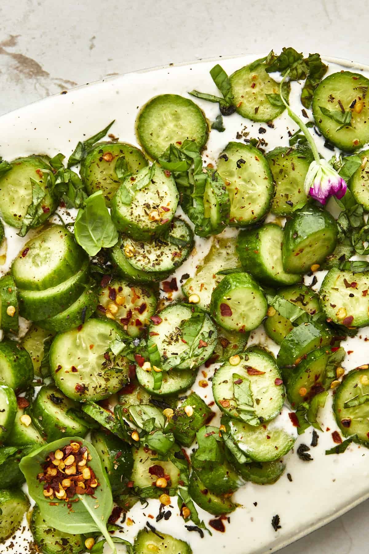Close up image of marinated cucumbers over cottage cheese dip.
