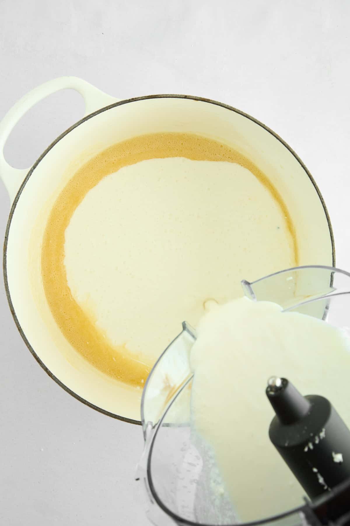 Cottage cheese sauce being poured into a pot of melted butter.