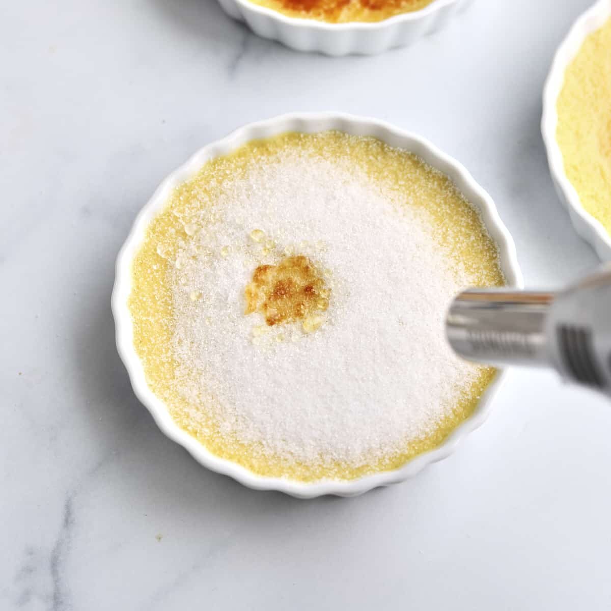 A kitchen torch caramelizes sugar.