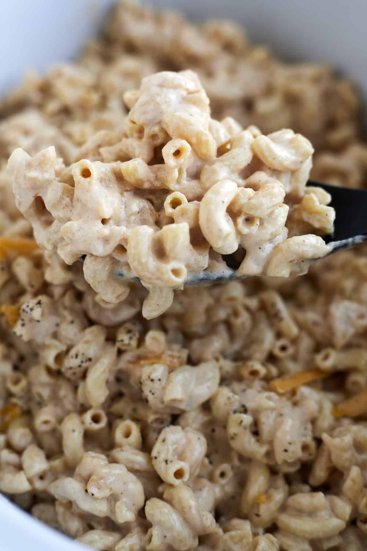 a close up image of a spoonful of crockpot mac and cheese.