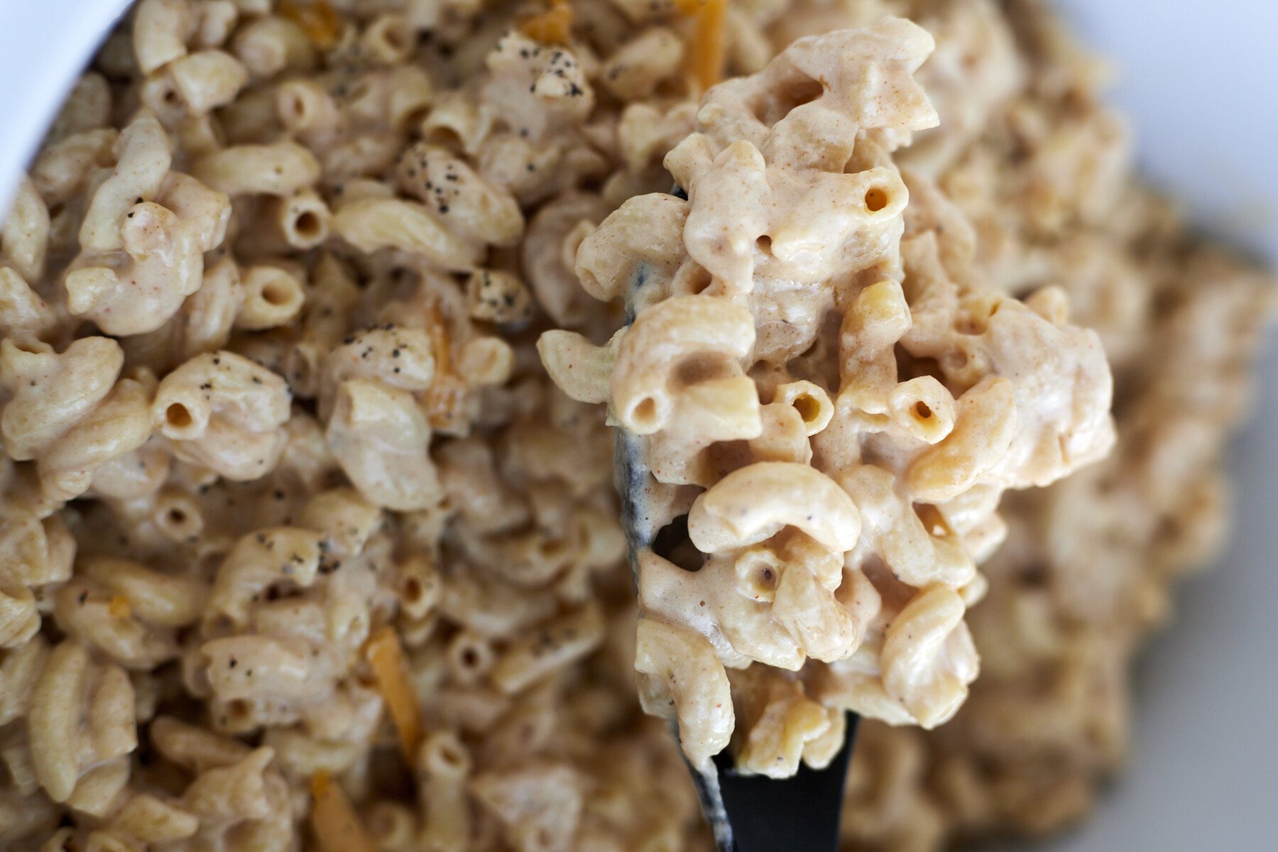 Crockpot mac and cheese being stirred.