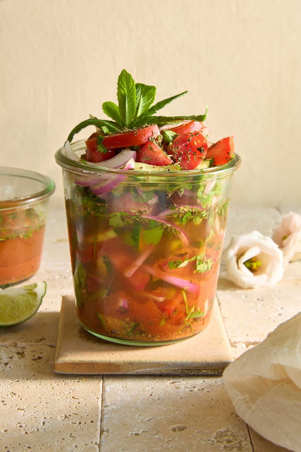 A jar of Egyptian cucumber and tomato salad in vinegar.