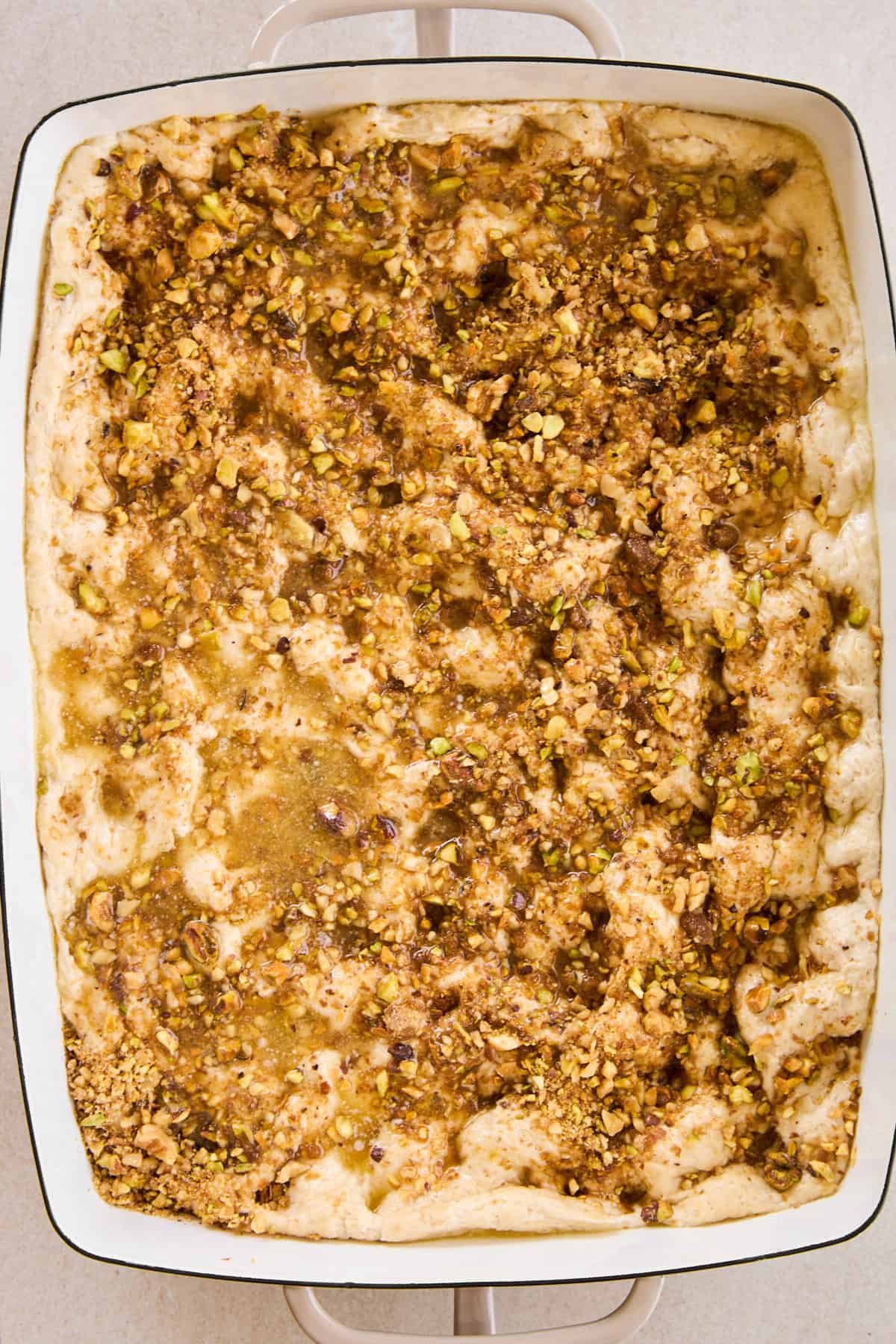Unbaked baklava dessert focaccia topped with a sweet nut mixture.