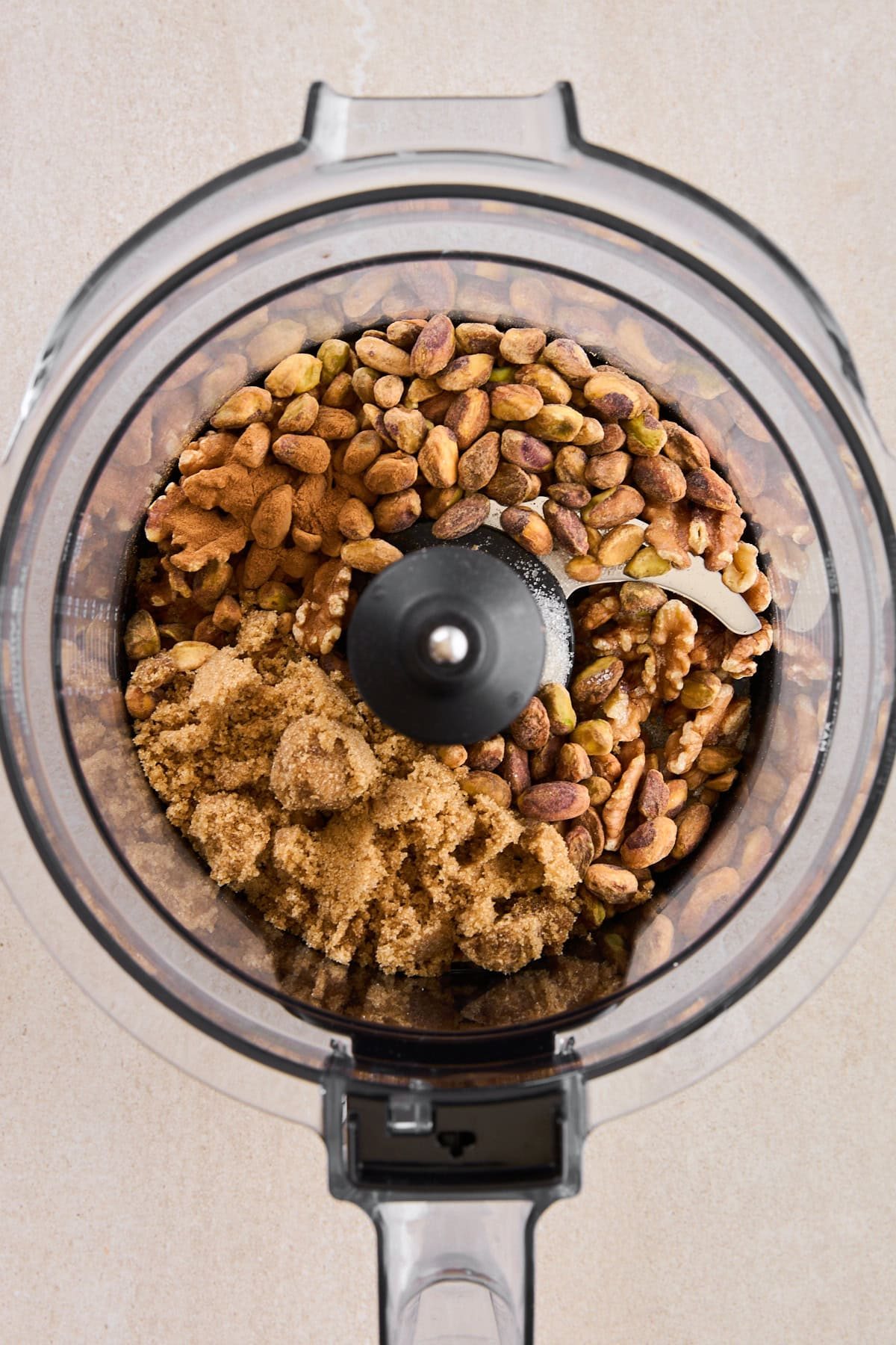 Pistachios and walnuts in a blender with brown sugar.