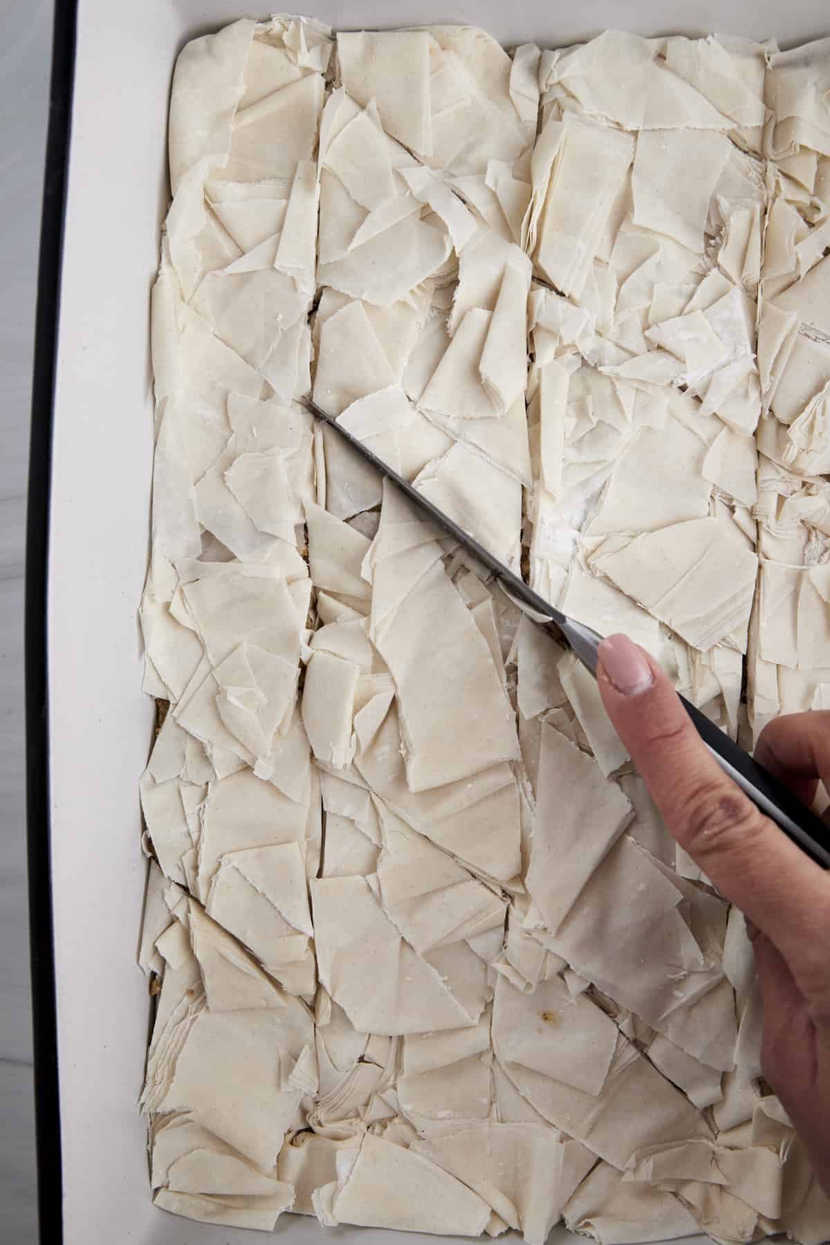 Unbaked easy baklava being sliced.