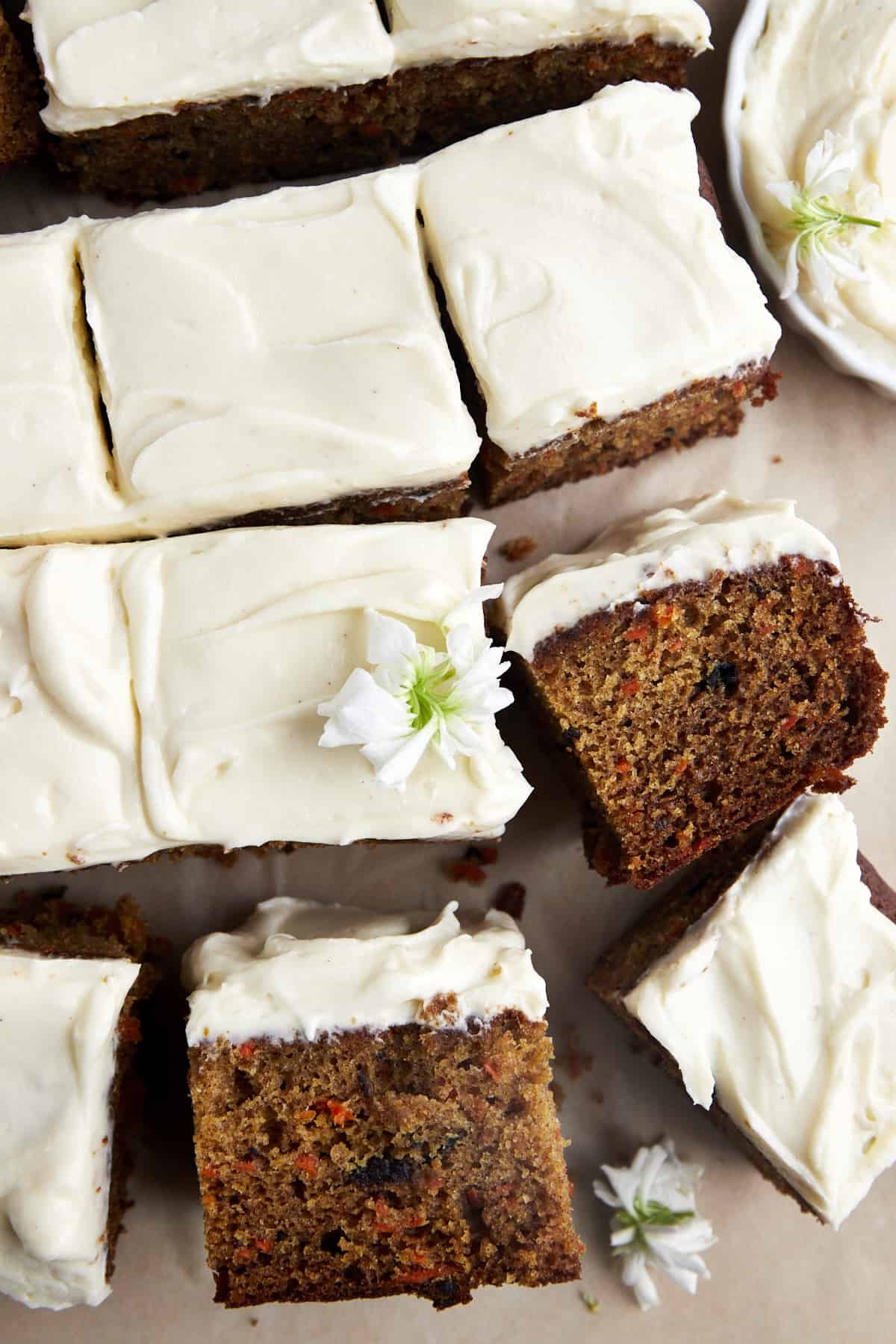 Squares of an easy carrot cake recipe topped with cream cheese frosting.