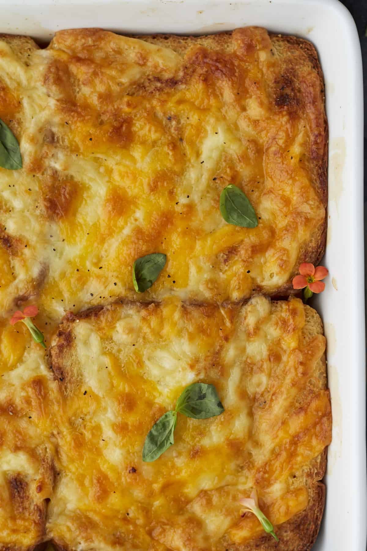 close up image of baked chicken fajita sandwiches in a square white baking dish