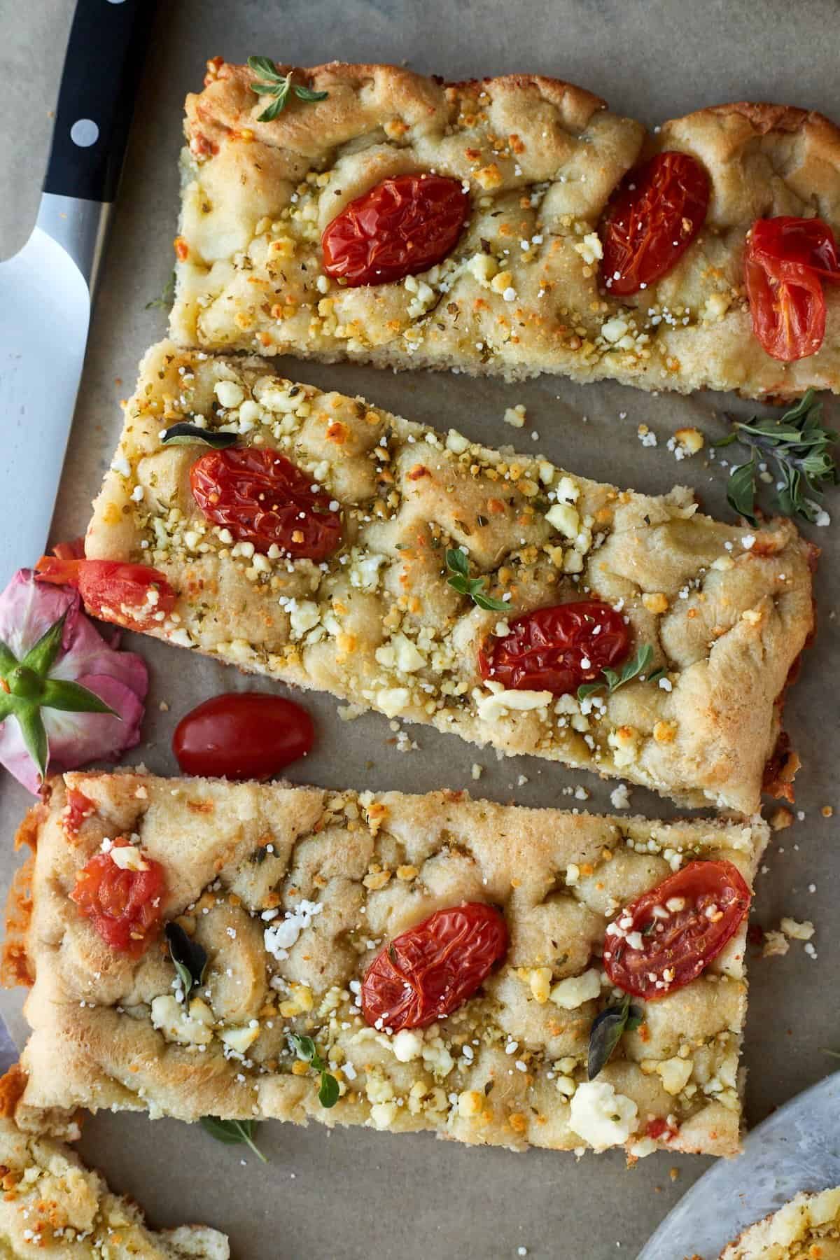 three sticks of simple focaccia bread with tomatoes and feta