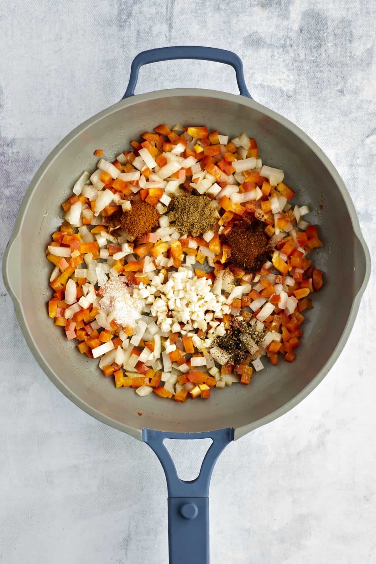 onions and peppers in a large pot with spices