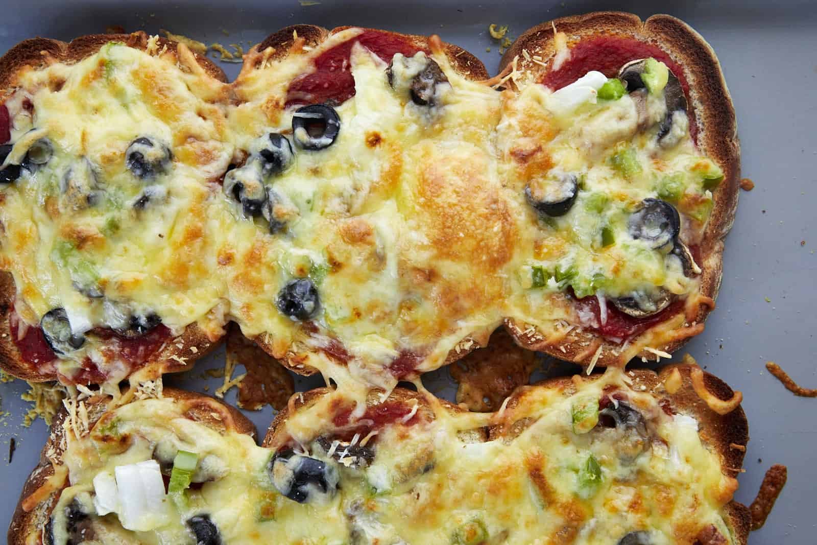 Baked sheet pan pizza made with bread pieces on a baking sheet.