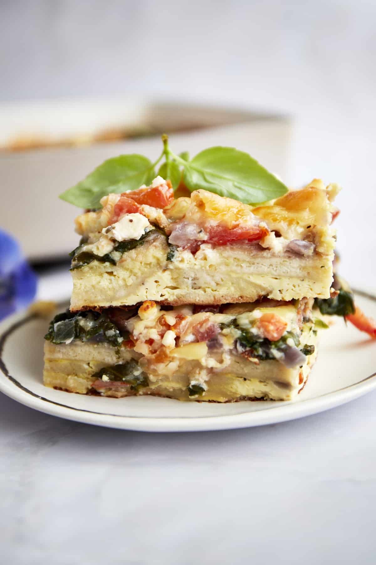 Side view of two slices of Greek egg bake casserole on a plate.