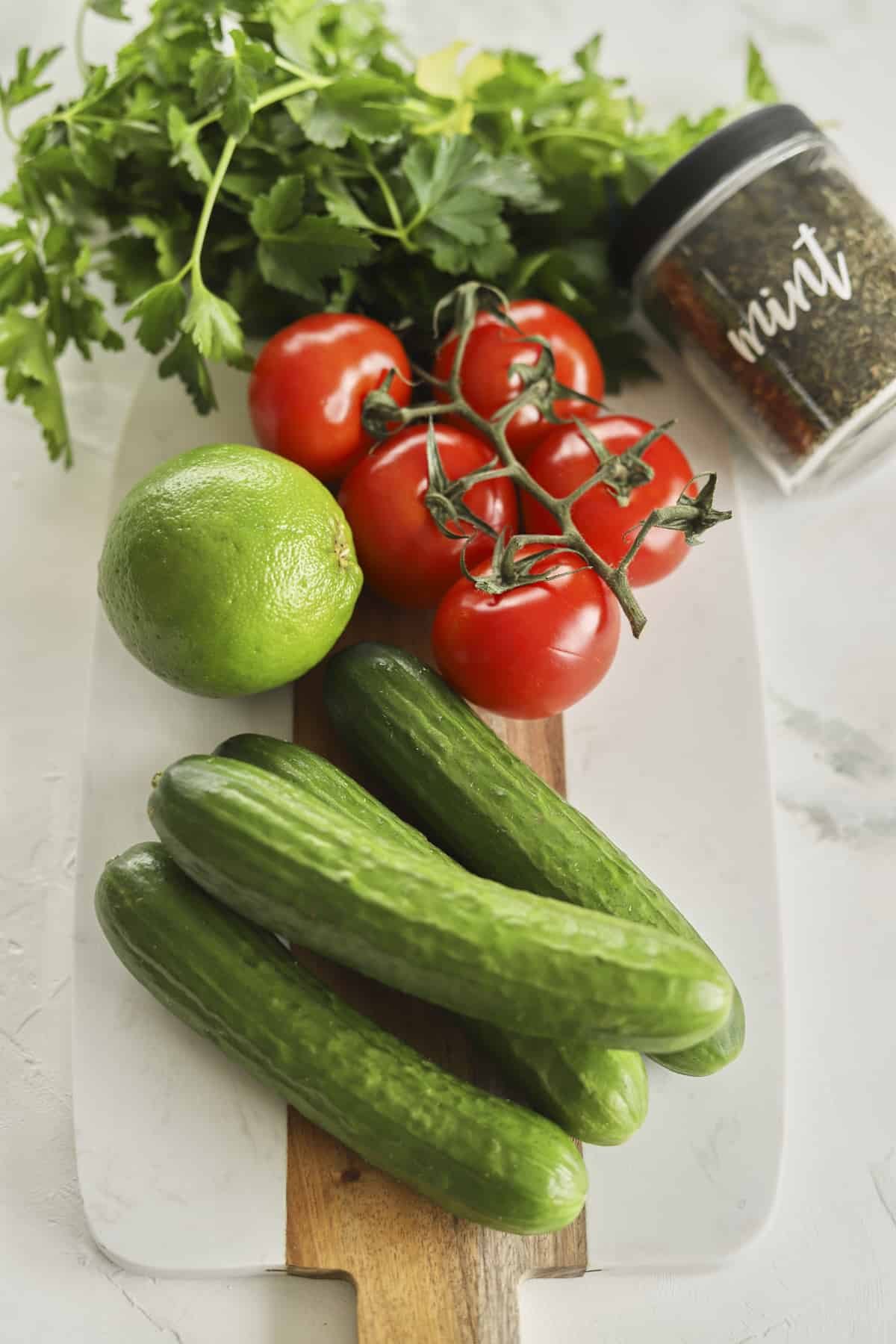 cucumber, tomato, lime, cilantro, and mint to make tomato and cucumber salad