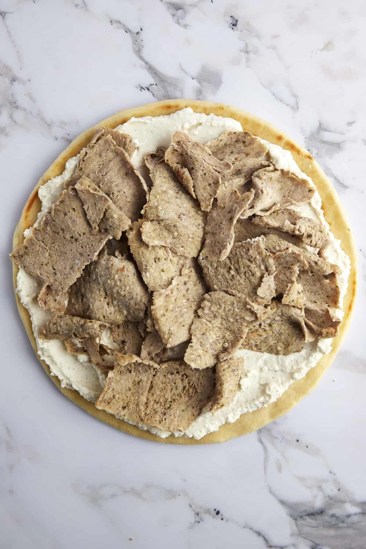 Pizza crust topped with whipped feta and shredded gyro meat.
