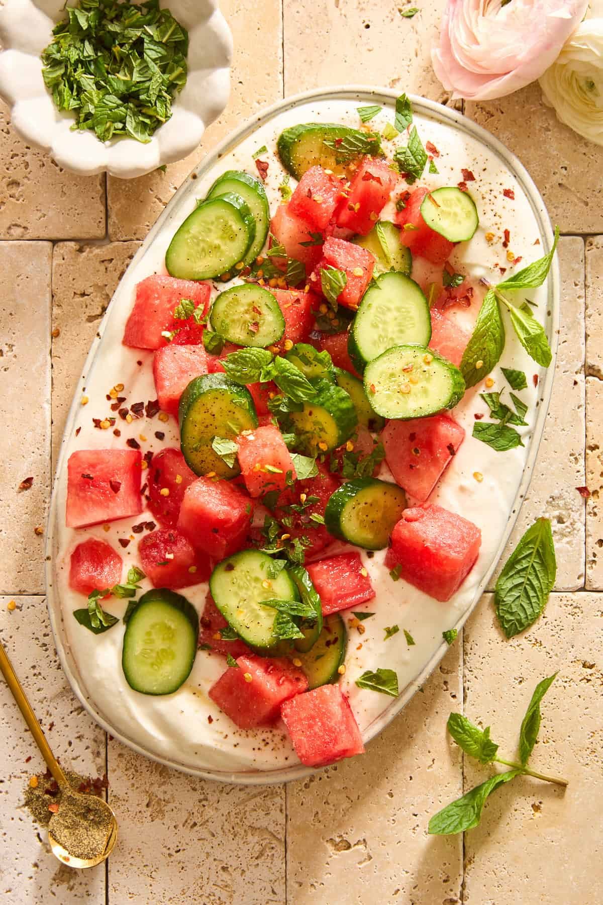 A platter of whipped feta topped with watermelon cucumber salad.