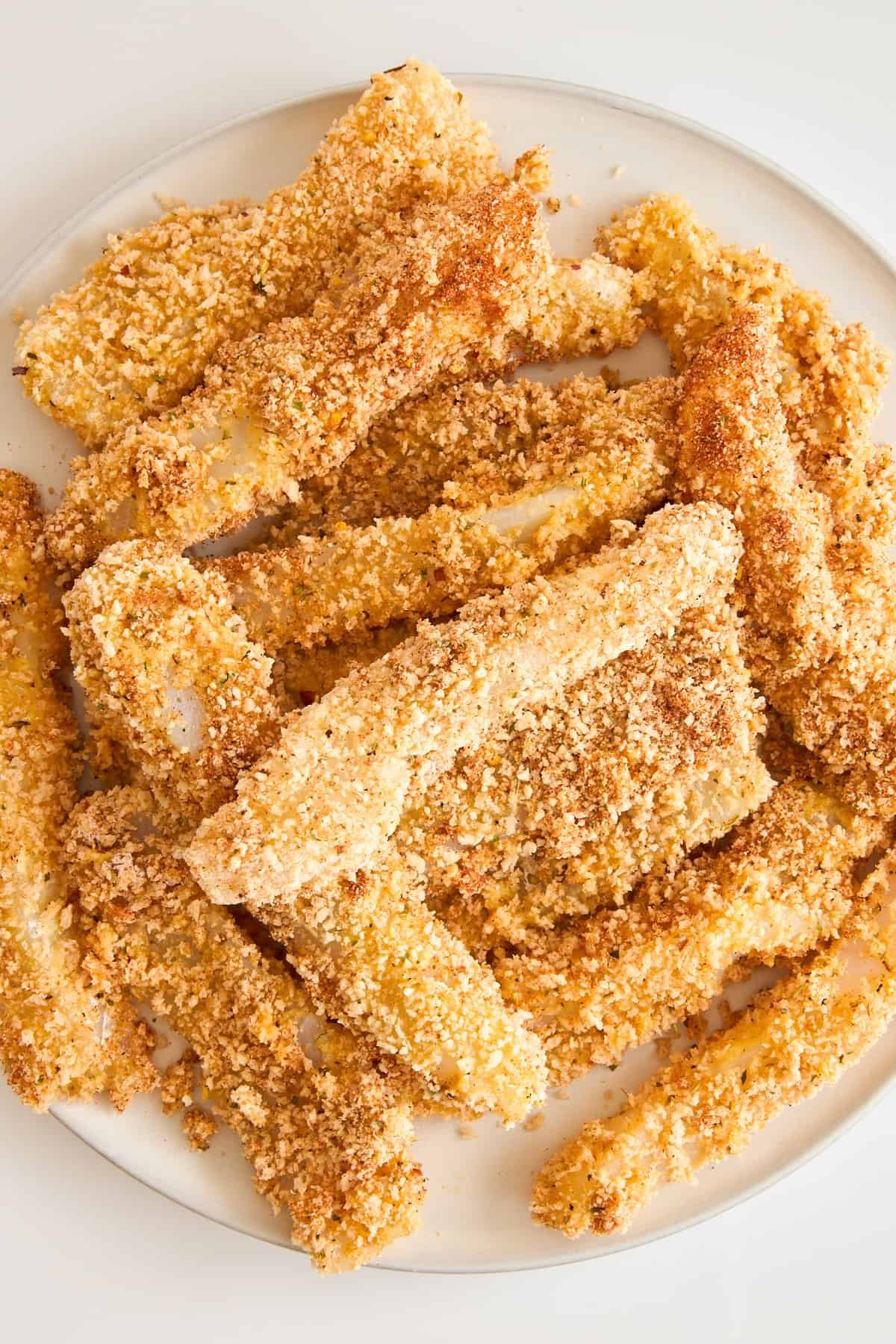 Homemade panko coated fish sticks on a plate.