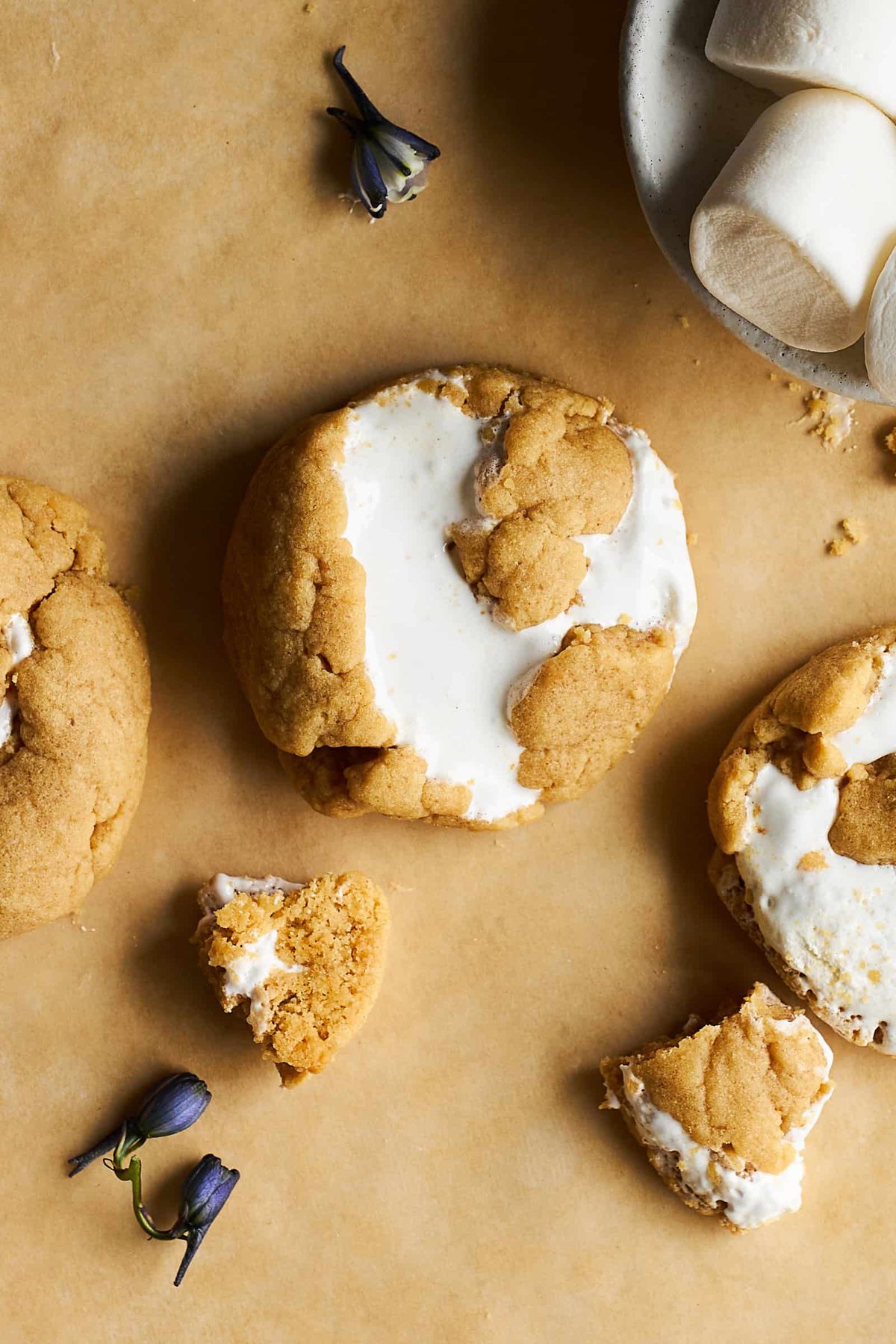 Whole peanut butter fluff cookies next to pieces of cookie.