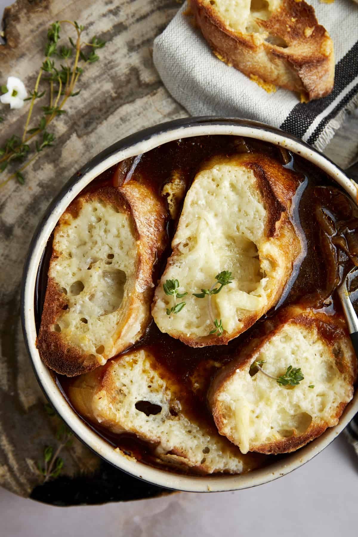 Overhead image of a bowl of simple French onion soup topped with toasted bread.