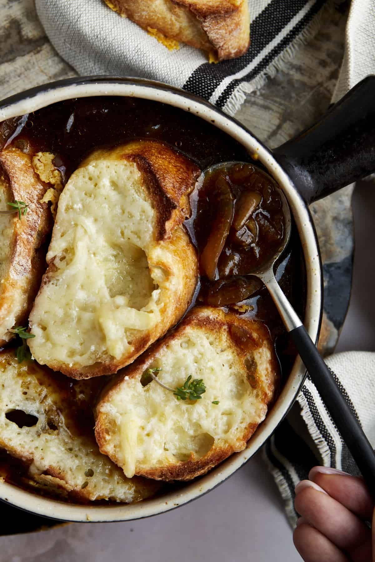 A spoon scooping up a bite of easy French onion soup.