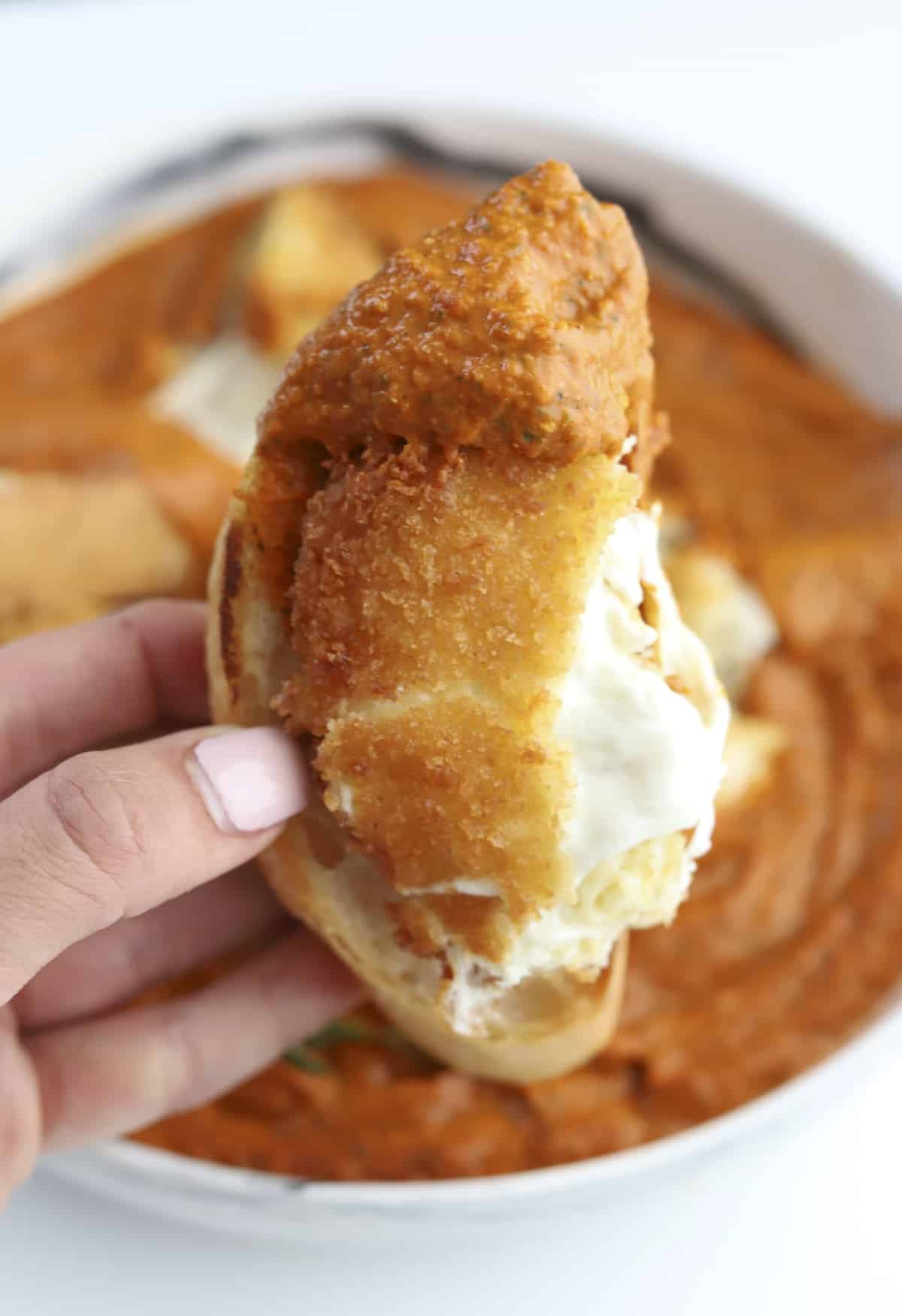 one fried burrata with romesco sauce on a baguette