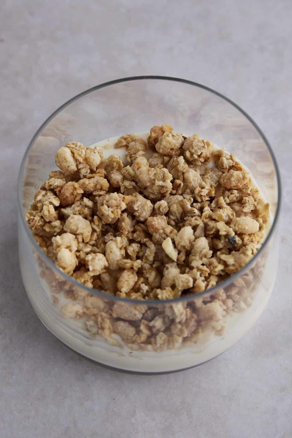 Granola layered on top of yogurt in a glass jar.