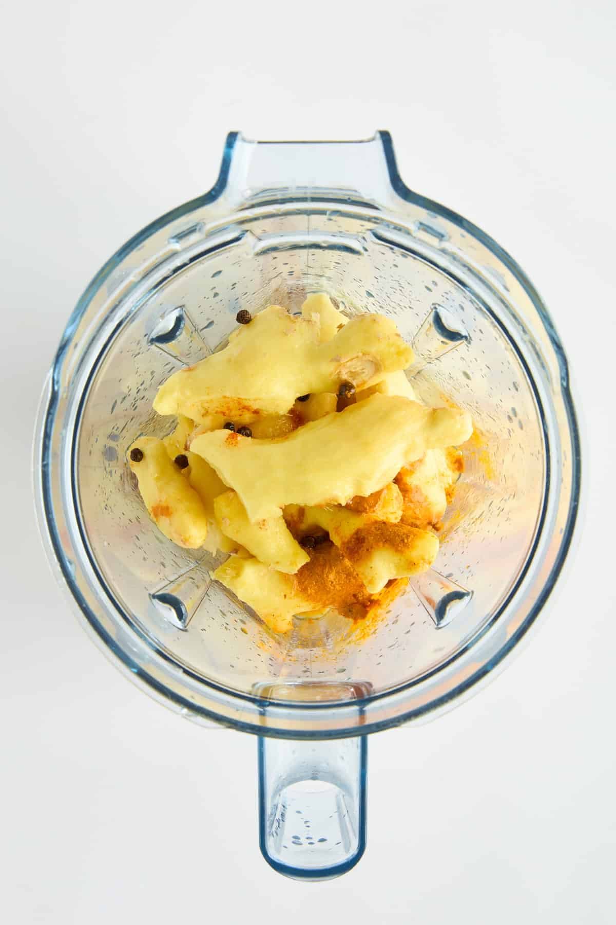 Ginger and turmeric shot ingredients in a blender.