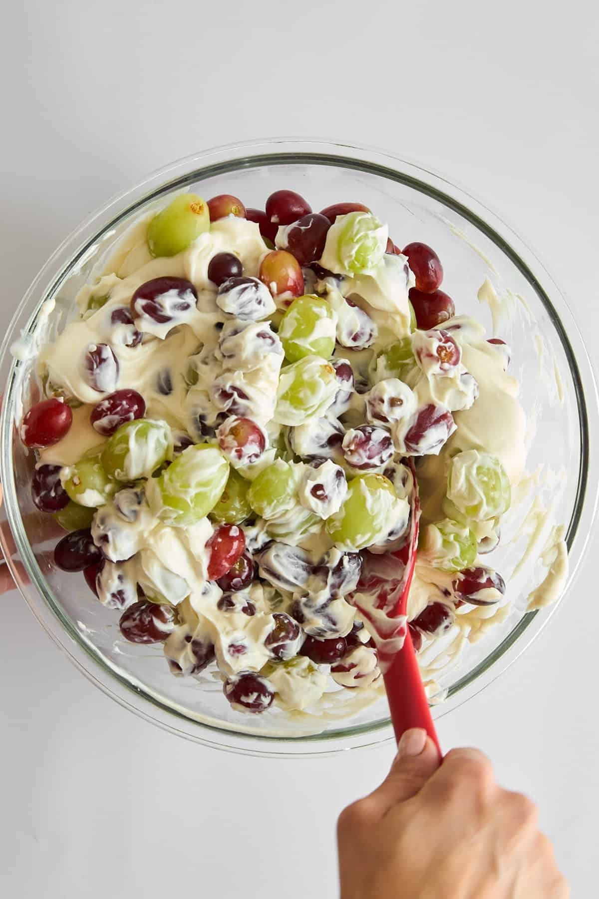 Grape salad being combined in a bowl.