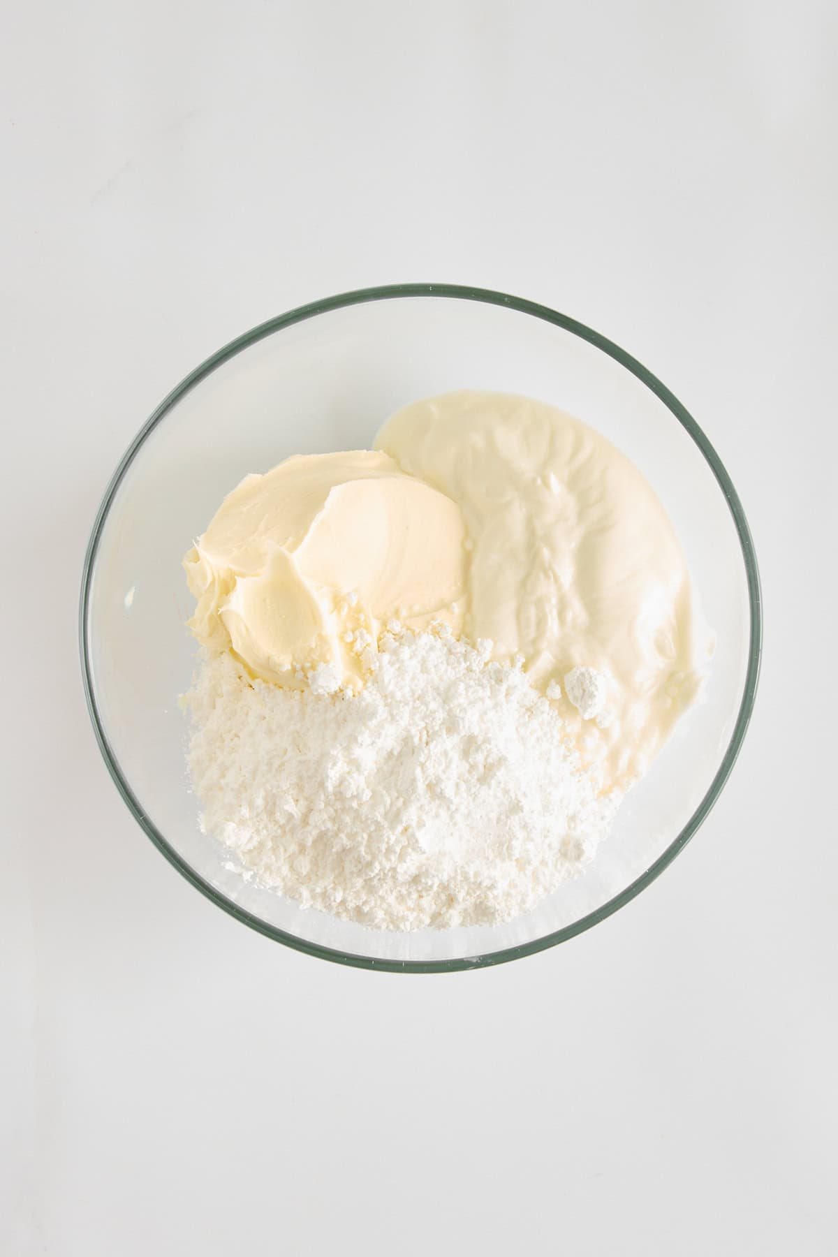 Powdered sugar, mascarpone, and Greek yogurt in a bowl.