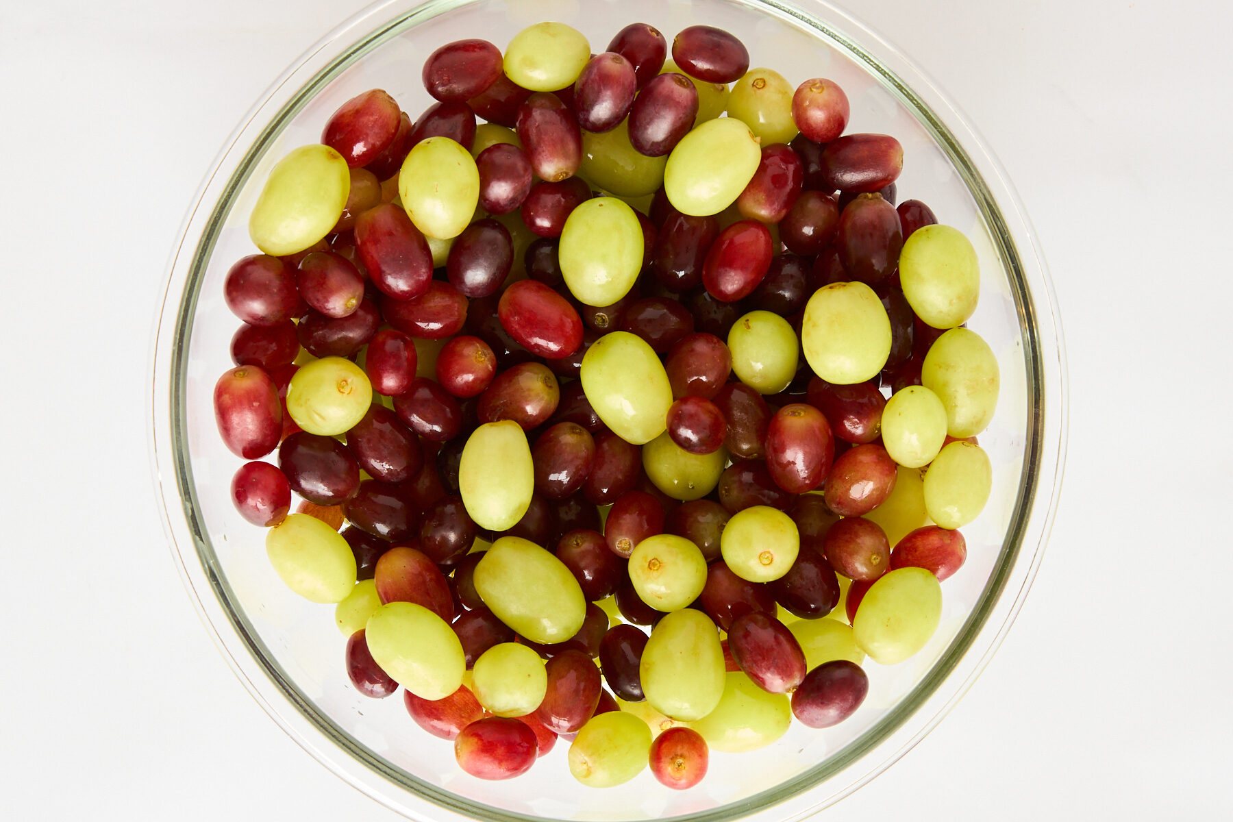 A bowl of red and green grapes.
