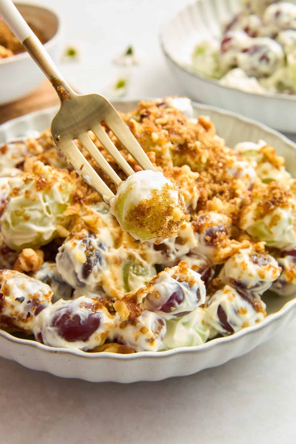 A fork holding a bite of grape salad.