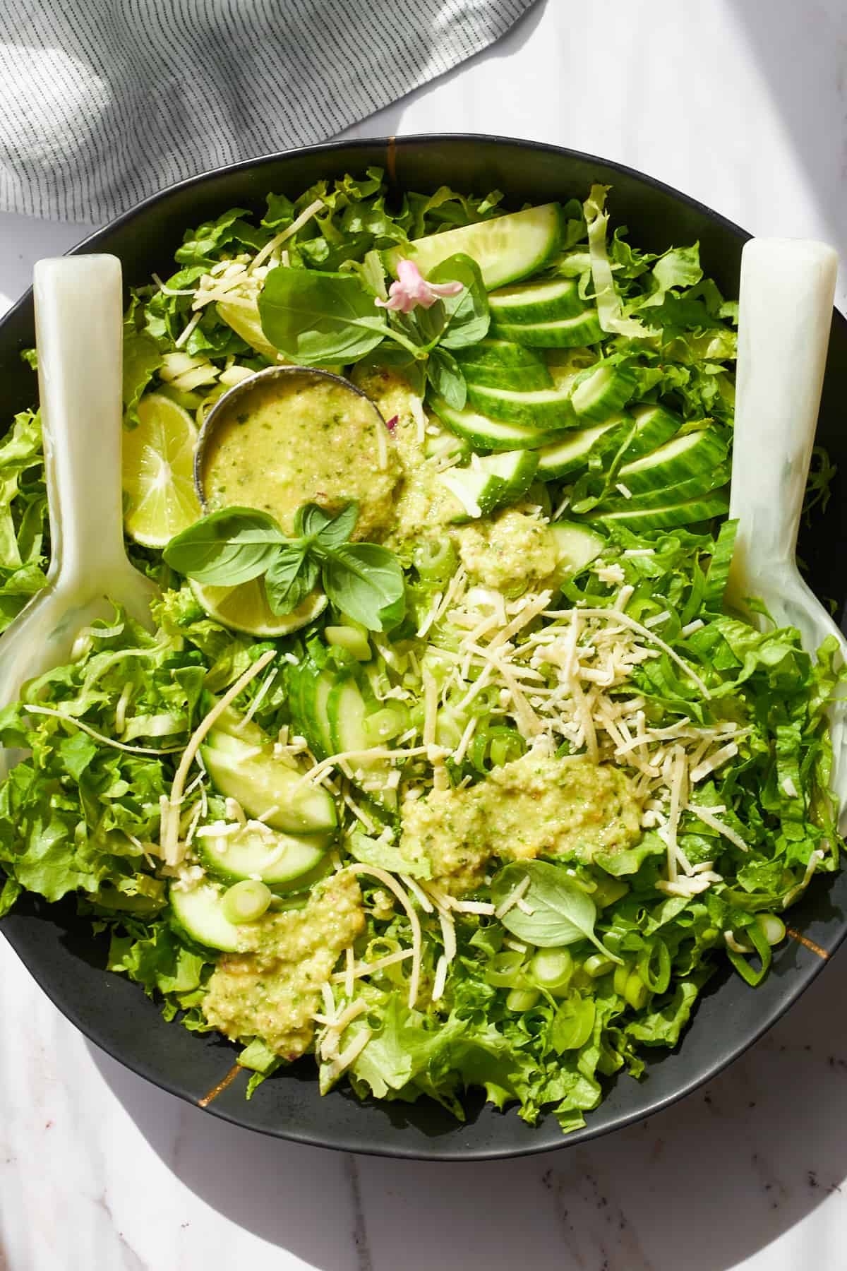 A bowl of green goddess dressing topped with green goddess salad.