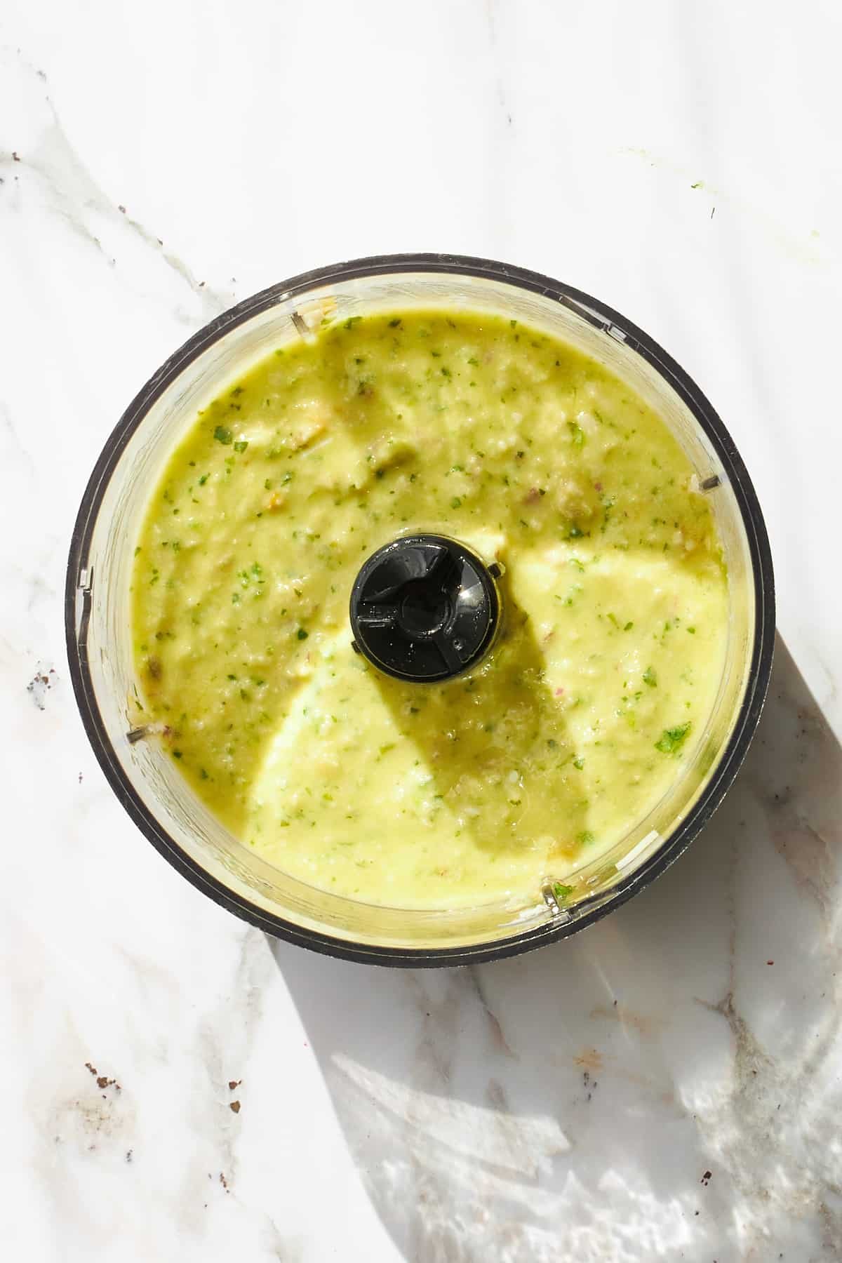 Blended green goddess dressing in a food processor.