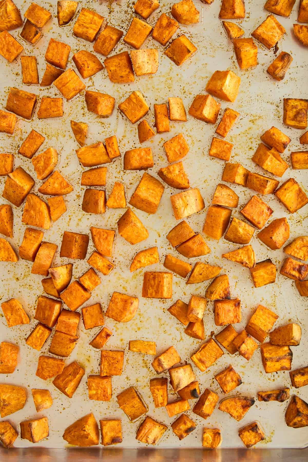 Roasted sweet potatoes on a sheet pan.