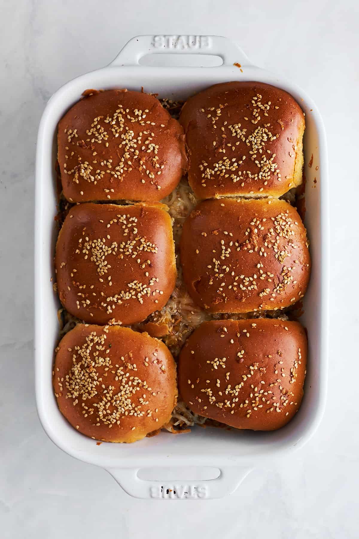 Baked cheeseburger sliders in a baking dish.