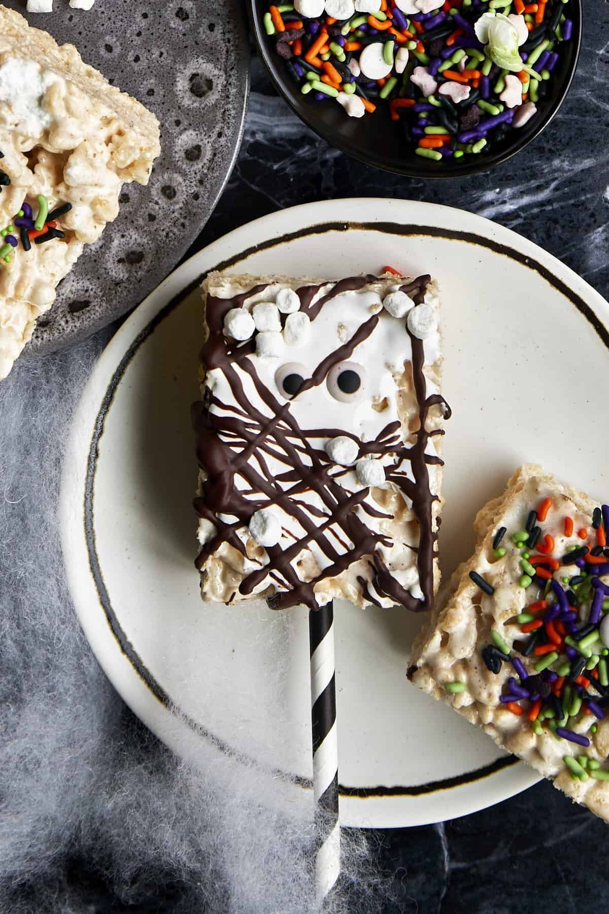 A Halloween rice krispie treat topped with chocolate, marshmallows, and candy eyes.