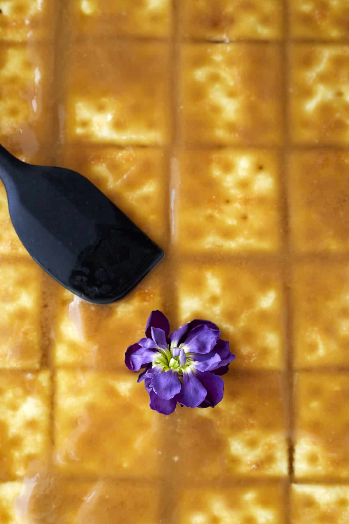 caramel sauce being spread on top of saltine crackers