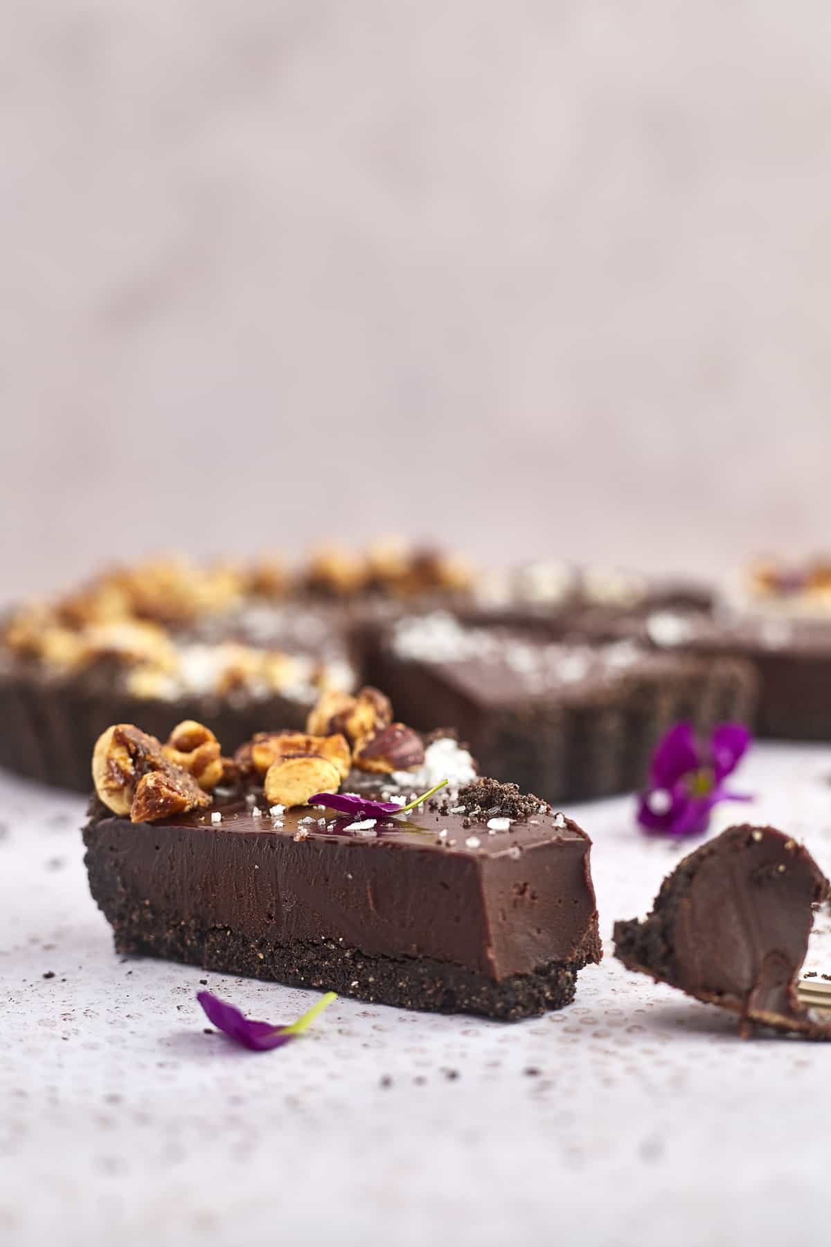 a chocolate tart with a fork next to it full of a bite of the slice
