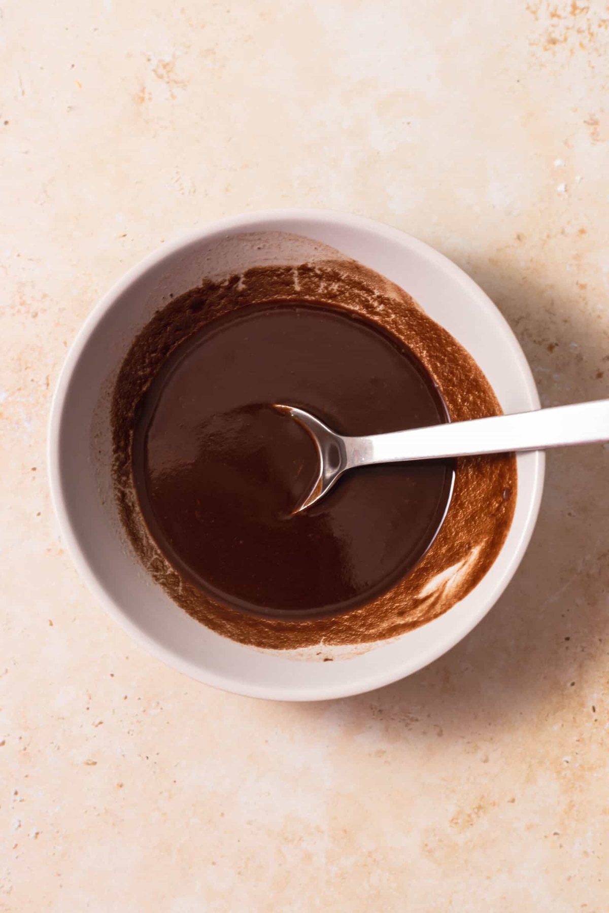 melted chocolate in a bowl with a spoon sticking out