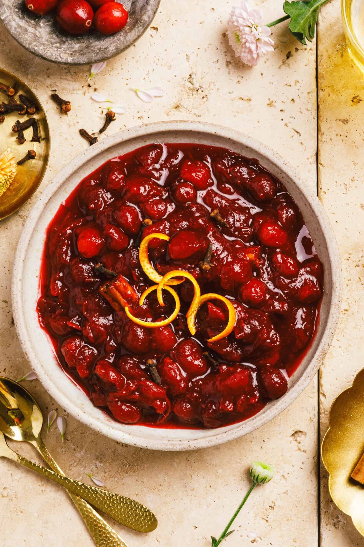 A bowl of from-scratch cranberry sauce topped with citrus peels.
