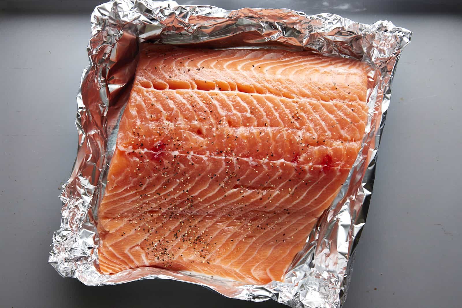 A large salmon filet in a foil packet.