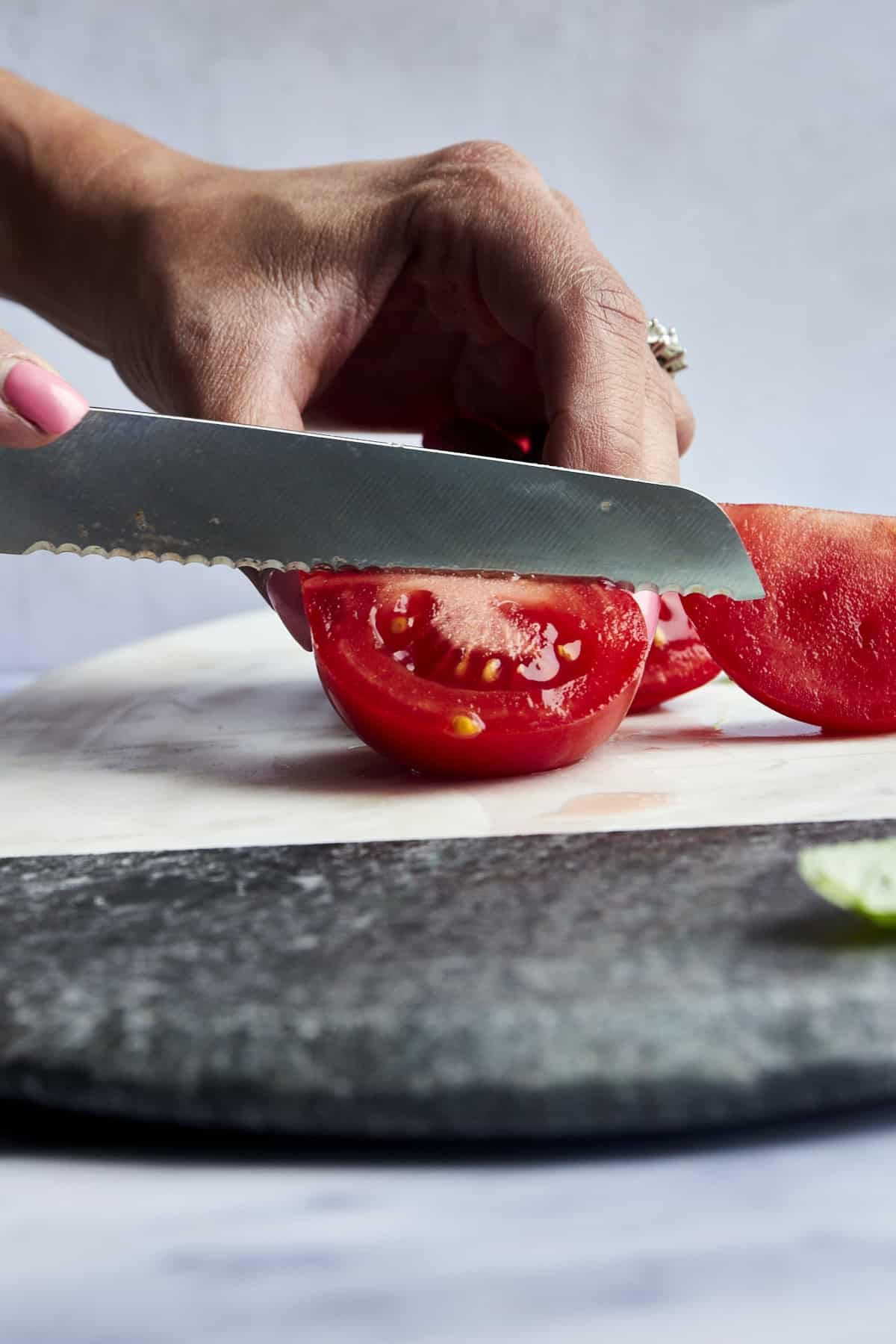 A tomato being quartered.