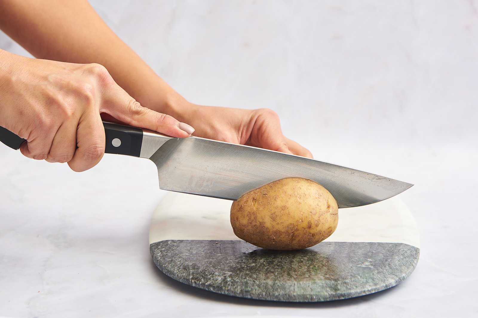 A potato being sliced in half.