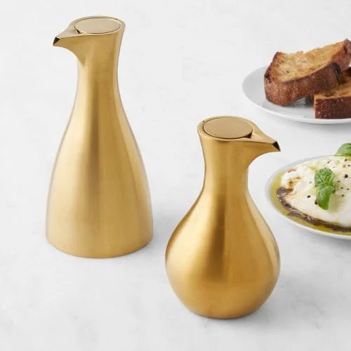 Two elegant golden oil dispensers.