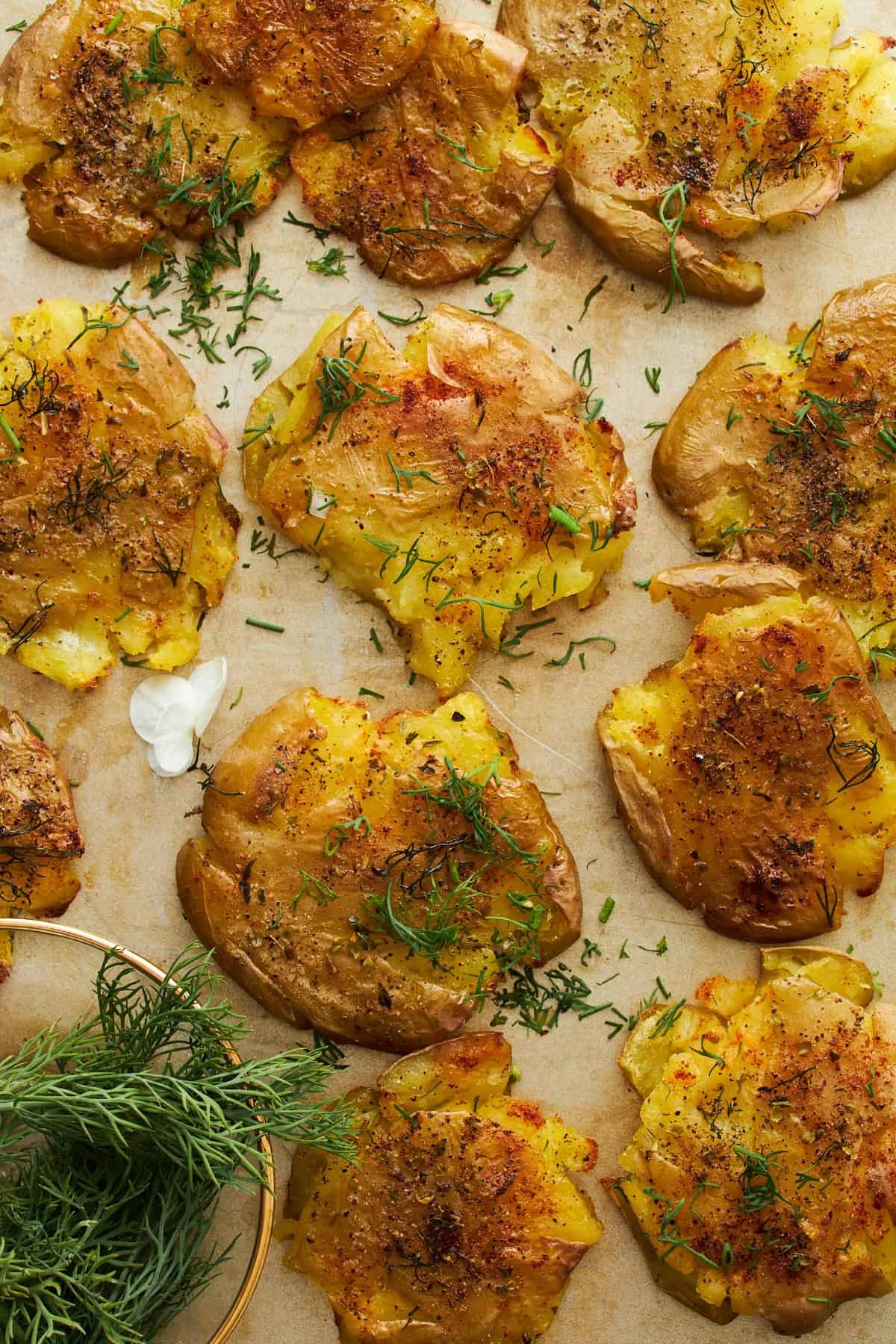 Crackly smashed potatoes on a baking sheet.